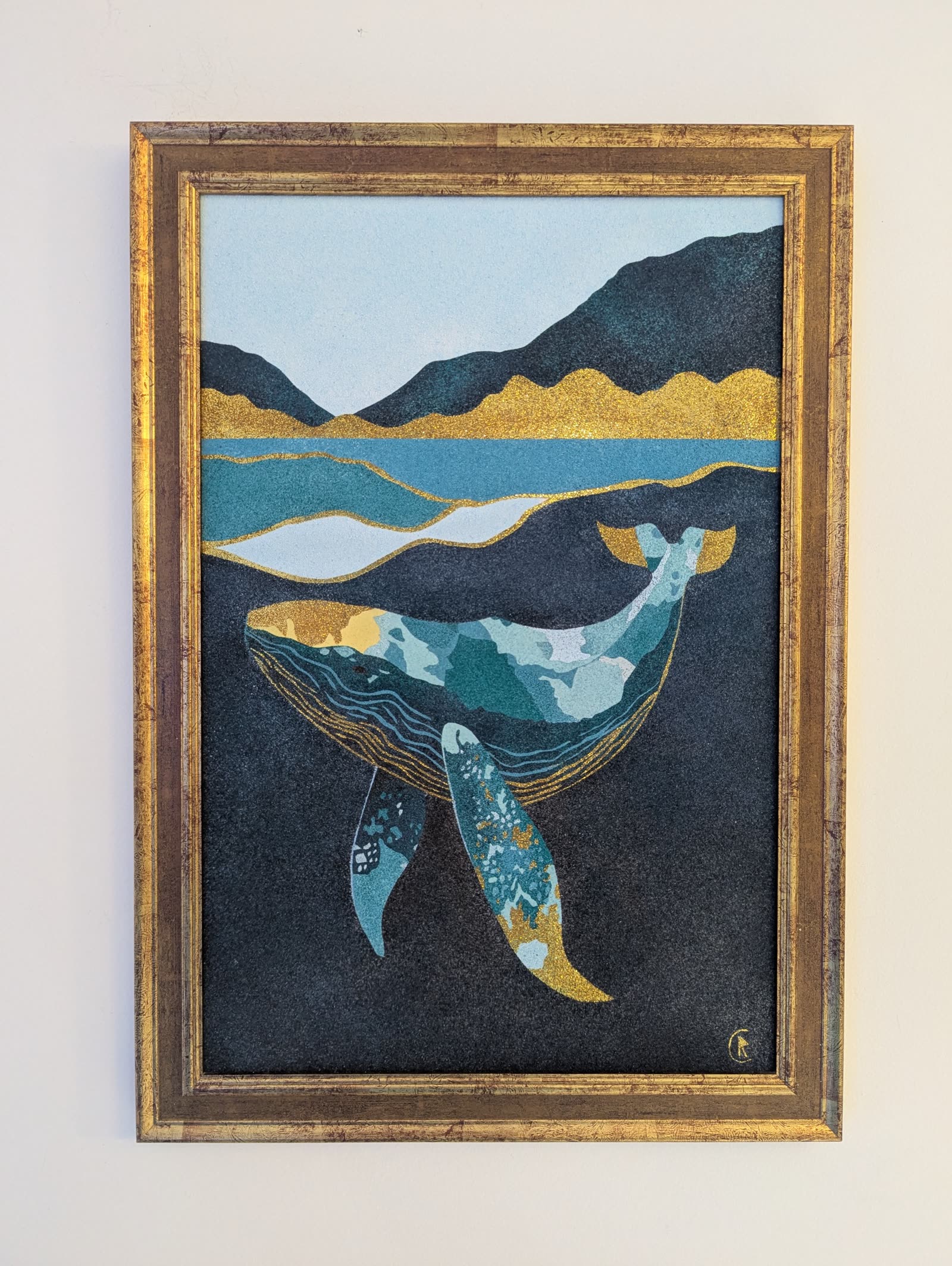 Baleine stylisée en bleu, vert et or plongeant au-dessus d'un paysage de montagnes et de lac, avec des touches de paillettes dorées.